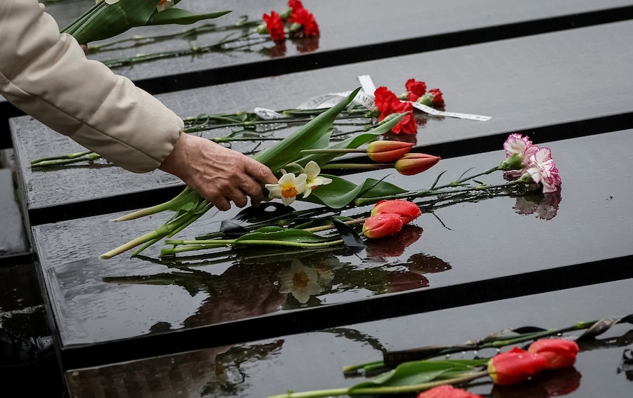 Una donna depone dei fiori presso un memoriale dedicato ai vigili del fuoco e agli operai deceduti in seguito all'esplosione di un reattore nella centrale nucleare di Cernobyl, mentre partecipa a una cerimonia commemorativa per il 40° anniversario del disastro di Cernobyl, a Kiev. (REUTERS)