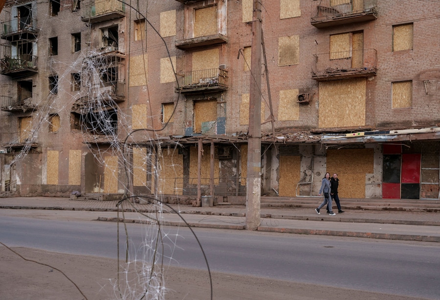 Persone che camminano accanto a un edificio danneggiato, nella città di Sloviansk, nella regione di Donetsk. (REUTERS/Serhii Korovainyi)