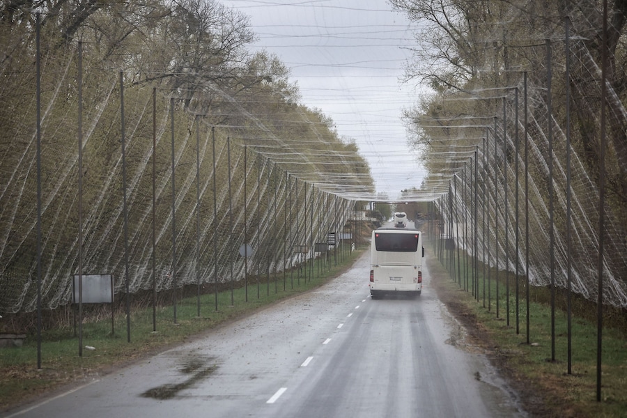 Un autobus percorre una strada ricoperta da una rete anti-droni nei pressi della centrale nucleare di Cernobyl, nella regione di Kiev. (REUTERS/Alina Smutko)