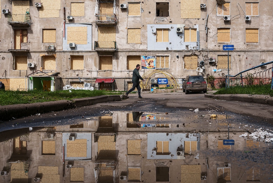 Un uomo cammina accanto a un edificio danneggiato, nella città di Kramatorsk, in prima linea nella regione di Donetsk. (REUTERS/Serhii Korovainyi)