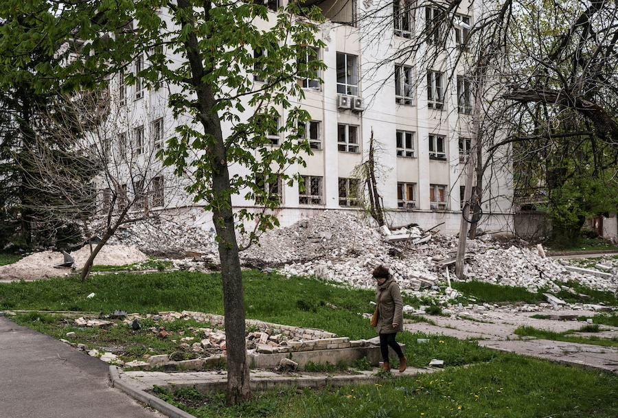 Una donna cammina accanto a un edificio danneggiato, , nella città di Kramatorsk, in prima linea nella regione di Donetsk. (REUTERS/Serhii Korovainyi)