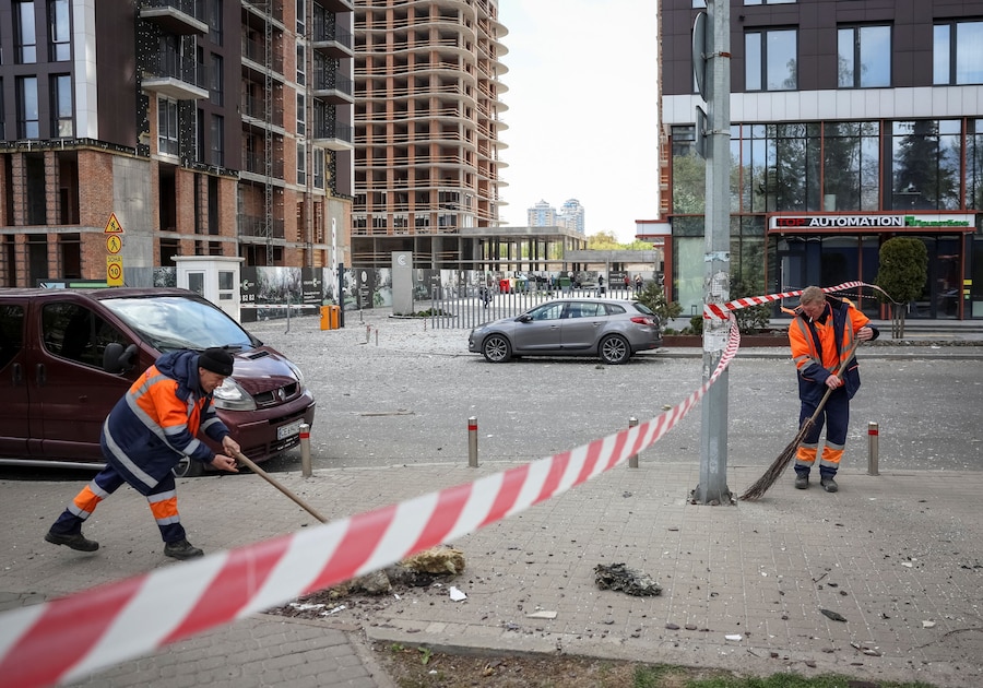 Operai comunali puliscono un'area colpita da un attacco con droni russi, a Kiev. (REUTERS/Gleb Garanich)