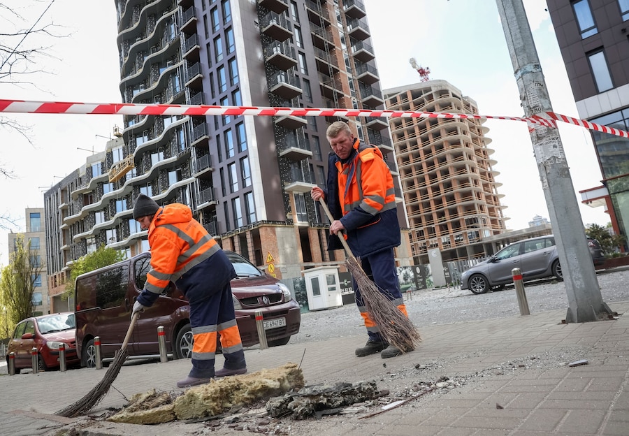 Operai comunali puliscono un'area colpita da un attacco con droni russi, a Kiev. (REUTERS/Gleb Garanich)