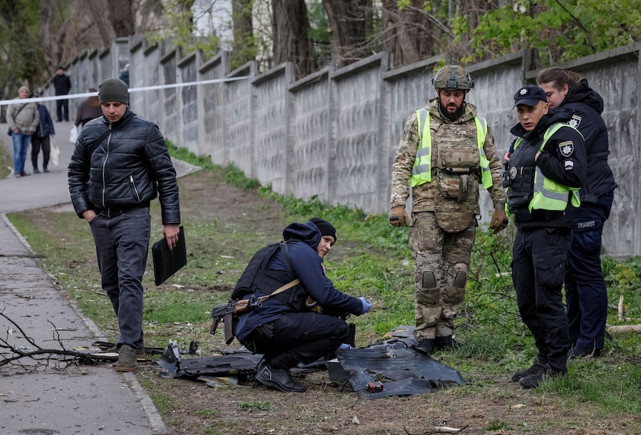 Un esperto della polizia opera sul luogo di un attacco sferrato da un drone russo, a Kiev. (REUTERS/Gleb Garanich)