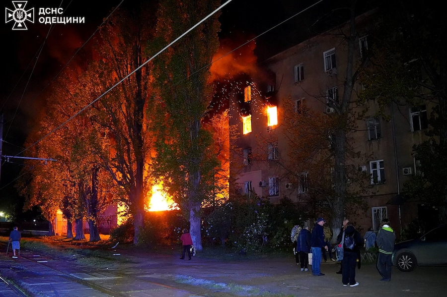 Alcuni residenti si trovano nei pressi di un condominio colpito da un attacco con droni russi, a Odessa. (Servizio stampa del Servizio statale di emergenza dell’Ucraina nella regione di Odessa/Foto fornita tramite REUTERS)