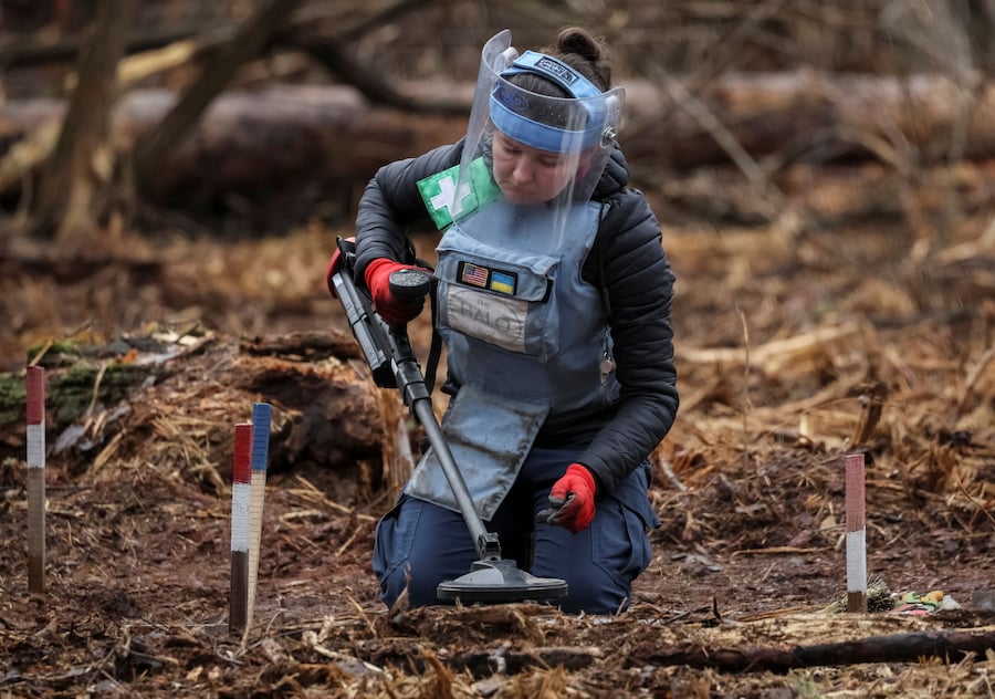 Un dipendente dell'HALO Trust (Hazardous Area Life-support Organization), un'organizzazione umanitaria non governativa che si occupa principalmente dello sminamento e della rimozione di altri ordigni esplosivi, utilizza un metal detector per cercare mine e ordigni inesplosi lasciati sul posto dopo l'occupazione russa della zona, nella regione di Kiev. (REUTERS/Gleb Garanich)