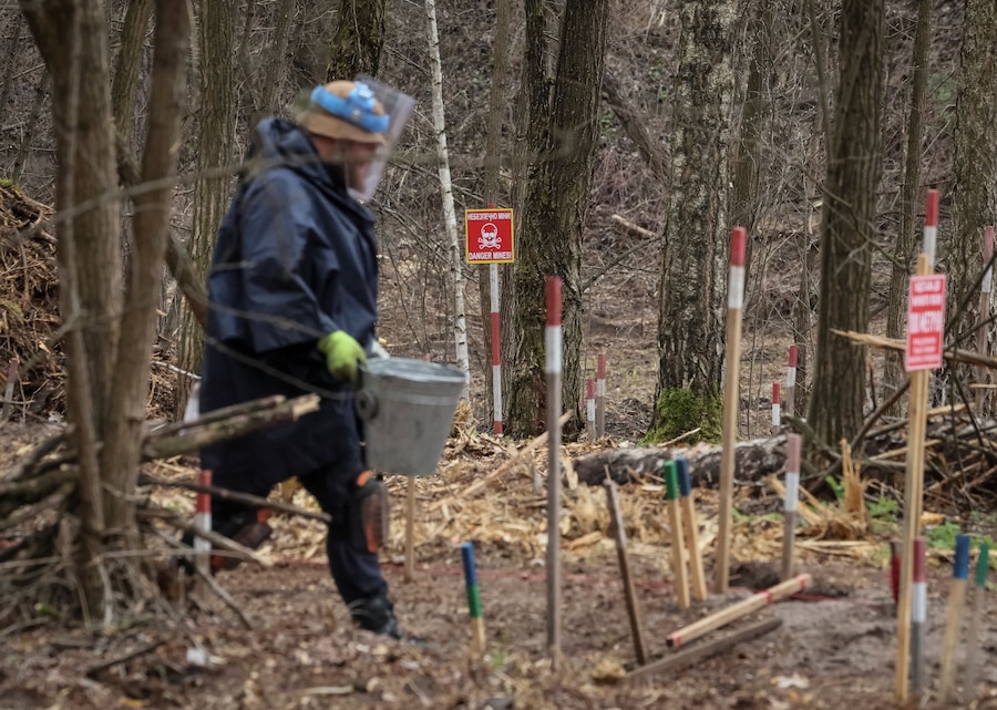 Un dipendente dell'HALO Trust (Hazardous Area Life-support Organization), un'organizzazione umanitaria non governativa che si occupa principalmente della bonifica di mine terrestri e altri ordigni esplosivi, cerca mine e ordigni inesplosi lasciati sul posto dopo l'occupazione russa della zona, nel contesto dell'attacco russo all'Ucraina, nella regione di Kiev. (REUTERS/Gleb Garanich)