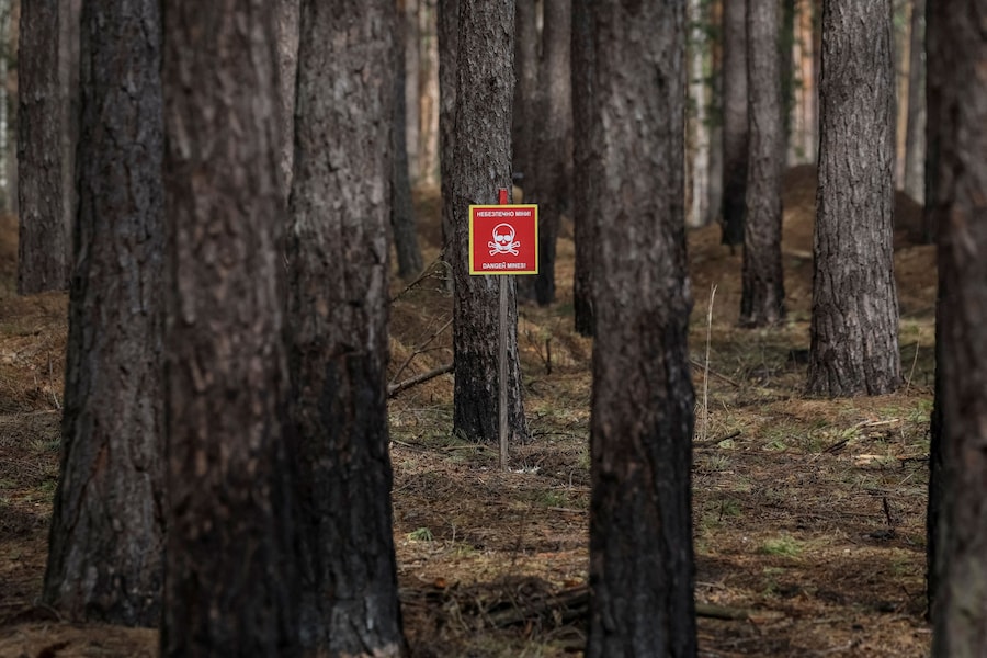 Un cartello avverte della presenza di mine in una foresta, nei pressi del villaggio di Myrotske, nella regione di Kiev. (REUTERS/Gleb Garanich)