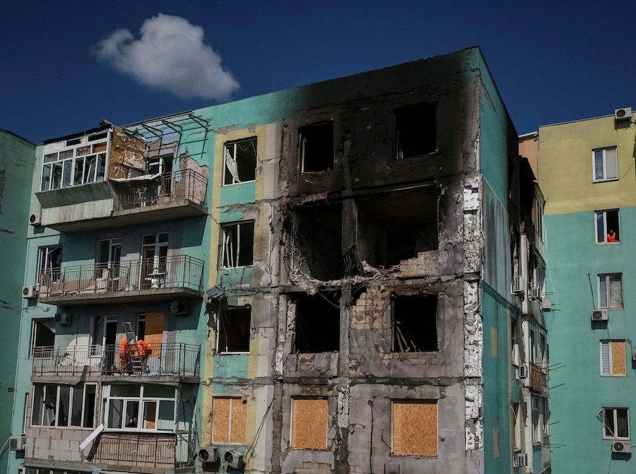 Operai comunali installano pannelli al posto delle finestre rotte in un condominio colpito da un attacco con droni russi a Odessa, Ucraina. (REUTERS)