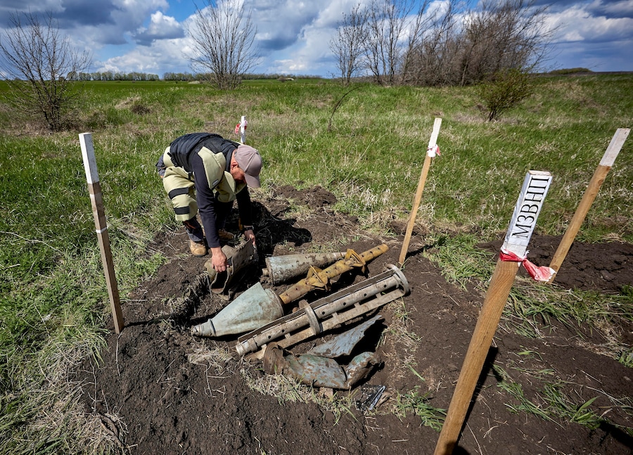 Vlontari del Fondo di beneficenza per lo sminamento dell'Ucraina lavorano in un campo per rimuovere mine terrestri e ordigni inesplosi e renderlo nuovamente coltivabile. (EPA)