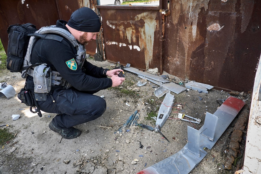 Un esperto ucraino esamina i detriti di un drone sul luogo di un attacco sferrato da un drone russo contro una stazione di servizio a Kharkiv. (EPA)