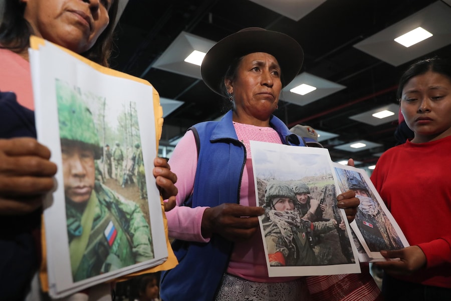 Alcune persone mostrano le foto di alcuni parenti che sarebbero stati reclutati dalla Russia per la guerra in Ucraina, chiedendo informazioni sulla loro sorte, all’aeroporto Jorge Chavez. Perù. (EPA)