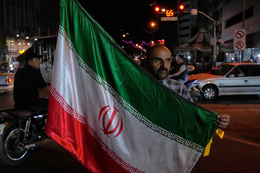Un uomo sventola una bandiera iraniana durante una manifestazione a sostegno del governo nel centro di Teheran, in Iran, venerdì 8 maggio 2026. (AP Photo/Vahid Salemi) (APN)