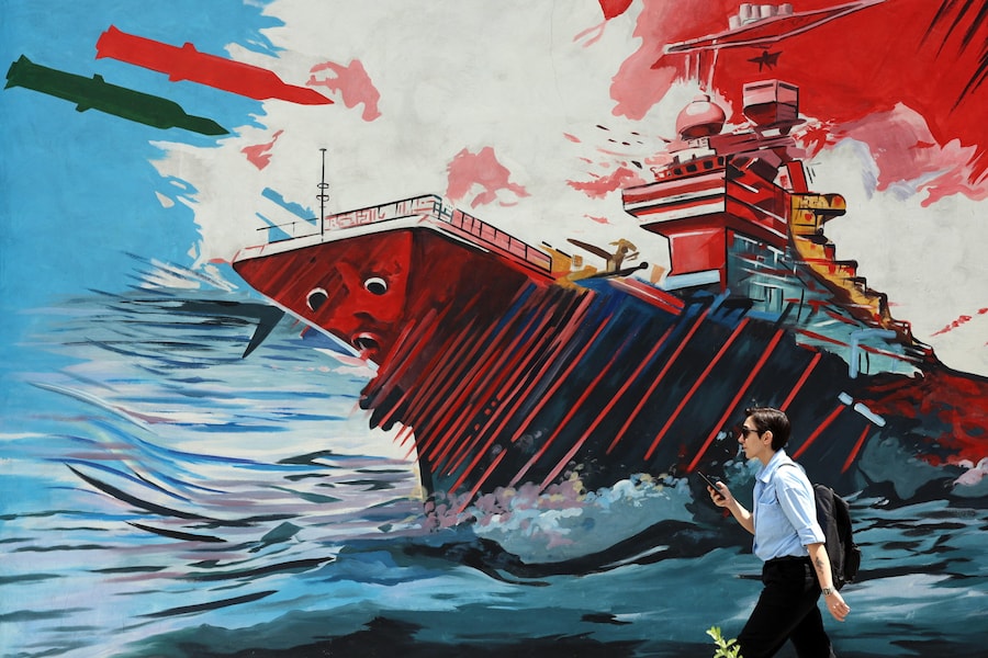 Un iraniano cammina accanto a un murale contro gli Stati Uniti e Israele in una strada di Teheran, in Iran, l'8 maggio 2026. L'Iran e gli Stati Uniti si sono scontrati a colpi di arma da fuoco nello Stretto di Ormuz, nonostante il cessate il fuoco. EPA/ABEDIN TAHERKENAREH (EPA)