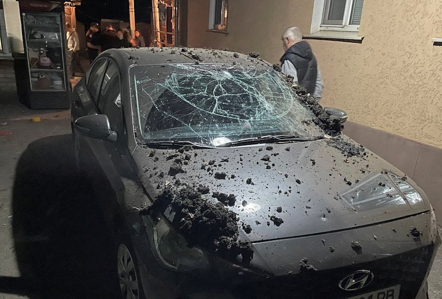 Un residente cammina vicino a un’auto danneggiata nel luogo di un attacco di un drone russo a Kryvyi Rih, nella regione di Dnipropetrovsk, Ucraina (REUTERS)