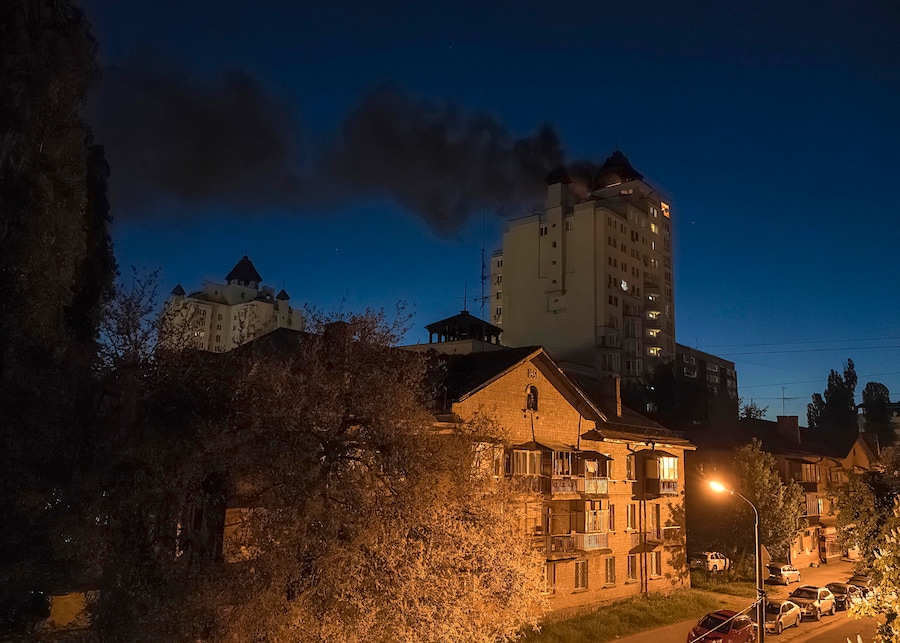 Una colonna di fumo si alza dopo che i detriti di un drone russo intercettato sono caduti sul tetto di un grattacielo residenziale a Kiev (EPA)