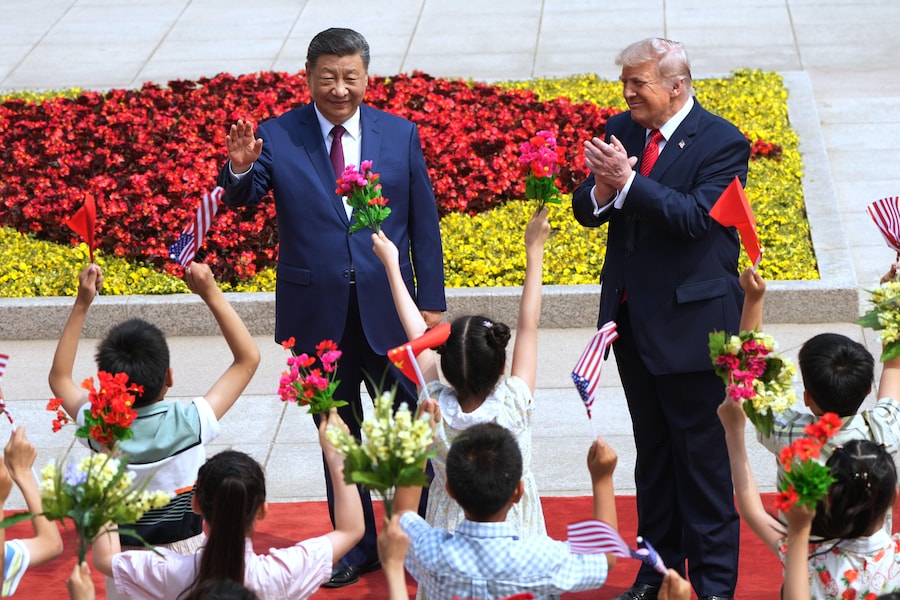 Il presidente Donald Trump e il presidente cinese Xi Jinping salutano alcuni bambini durante una cerimonia di benvenuto alla Grande Sala del Popolo, giovedì 14 maggio 2026, a Pechino. (APN)