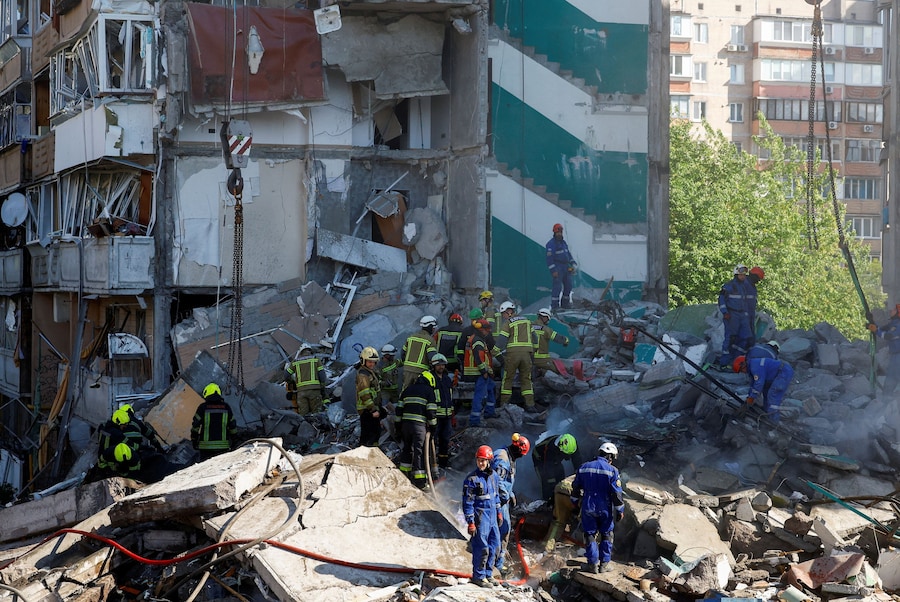 I soccorritori lavorano sul luogo dell’attacco missilistico e con droni contro un condominio russo a Kiev (REUTERS)