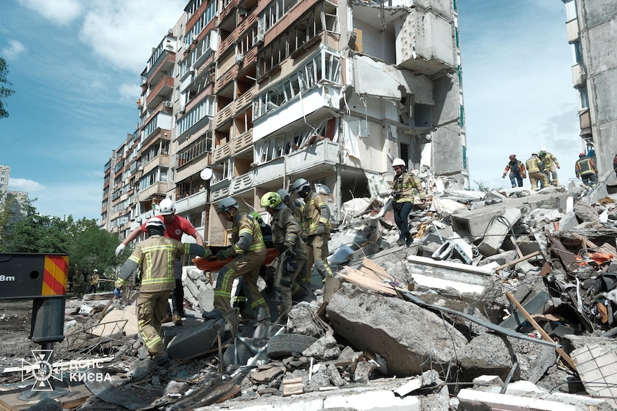 I soccorritori trasportano il corpo di una persona estratto dalle macerie di un condominio danneggiato durante gli attacchi missilistici e con droni russi a Kiev (via REUTERS)