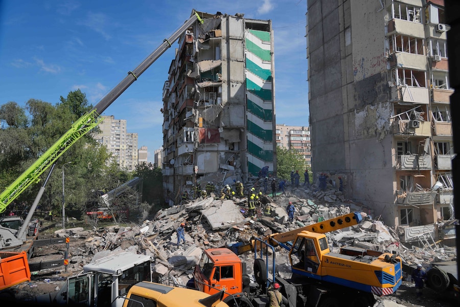 I soccorritori rimuovono le macerie dopo che un missile russo ha colpito un condominio durante un massiccio attacco aereo a Kiev (APN)