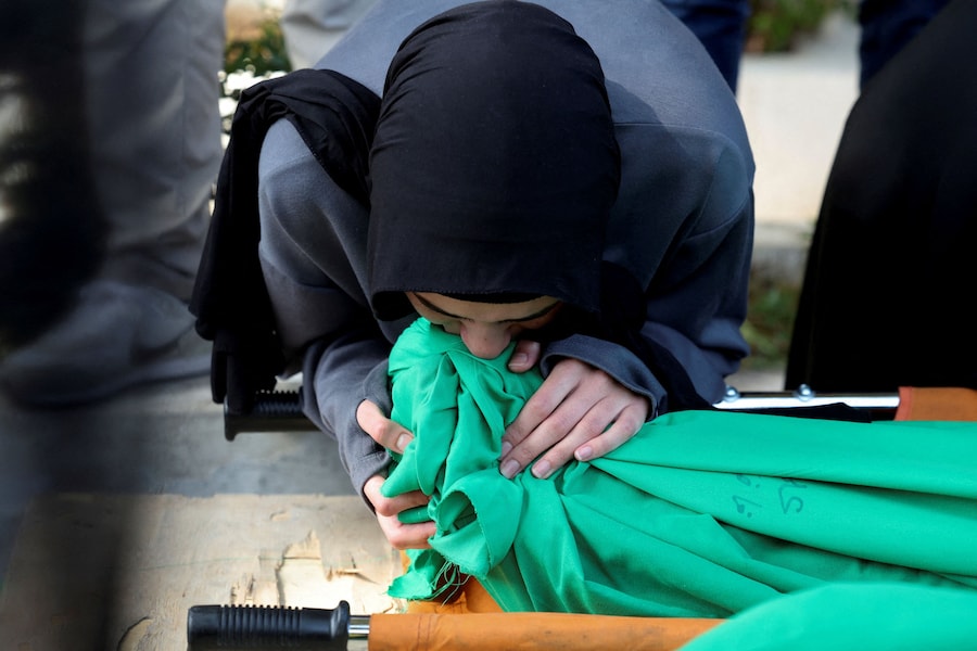 Un partecipante al funerale bacia il corpo di una vittima durante la cerimonia funebre per le persone uccise in un attacco israeliano a Saksakiyeh, Haret Saida, distretto di Sidone, Libano (REUTERS)