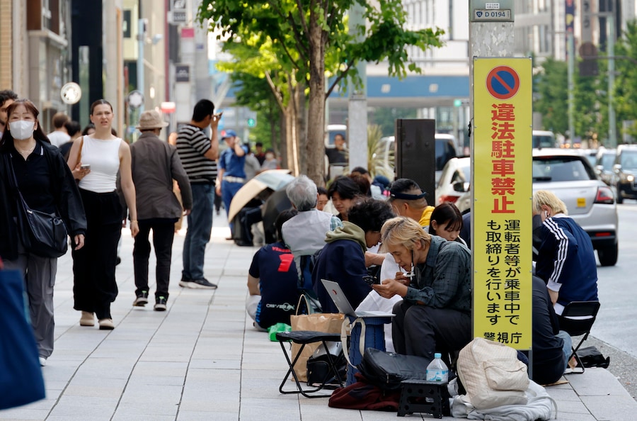 1 Una fila di persone si snoda davanti al negozio Swatch NGHC di Ginza a Tokyo, in Giappone (EPA)