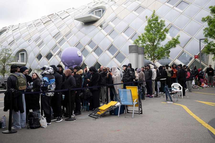 La gente attende l'apertura del negozio per acquistare il nuovo orologio Royal Pop di Swatch e Audemars Piguet all'esterno dello Swatch Drive-Thru Store, situato accanto alla sede centrale di Swatch a Biel/Bienne, in Svizzera (EPA)