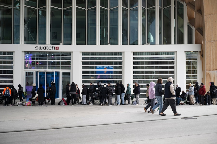 La gente attende l'apertura del negozio per acquistare il nuovo orologio Royal Pop di Swatch e Audemars Piguet davanti allo Swatch Drive-Thru Store, situato accanto alla sede centrale di Swatch a Biel/Bienne, in Svizzera (EPA)