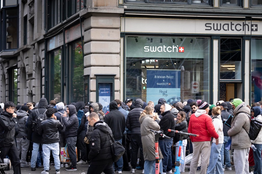 La gente fa la fila fuori dal negozio Swatch in Bahnhofstrasse per acquistare gli orologi della nuova collezione realizzata in collaborazione tra Swatch e Audemars Piguet (Royal Pop) a Zurigo, in Svizzera (EPA)