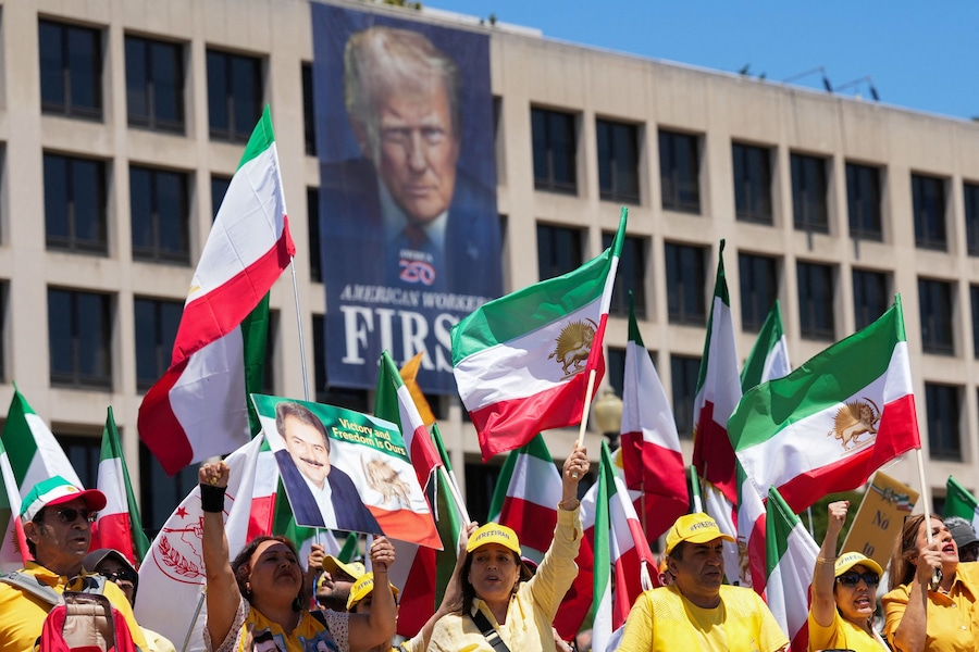 Cittadini iraniani americani e sostenitori del Consiglio Nazionale della Resistenza Iraniana partecipano a una marcia che passa davanti al Dipartimento del Lavoro degli Stati Uniti con uno striscione raffigurante l’immagine del presidente statunitense Donald Trump, a Washington, D.C., Stati Uniti (REUTERS)