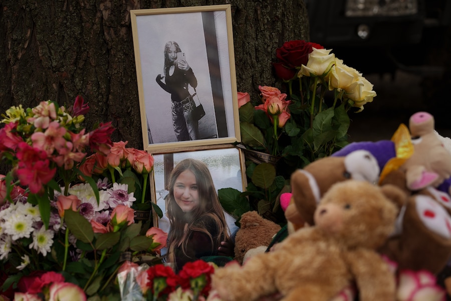 Le foto di una ragazza rimasta uccisa sono visibili tra i fiori vicino a una casa gravemente danneggiata in seguito a un attacco russo contro un quartiere residenziale di Kiev. (AP Photo/Evgeniy Maloletka/APN)