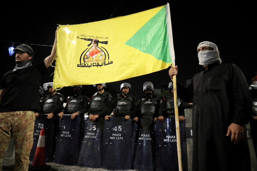 Le forze di sicurezza irachene montano la guardia mentre i manifestanti si radunano davanti al consolato del Kuwait dopo che alcuni razzi lanciati dalla direzione del Kuwait hanno colpito un'abitazione a Khor al-Zubair, Bassora, Iraq, il 7 aprile 2026. REUTERS/Mohammed Aty (REUTERS)