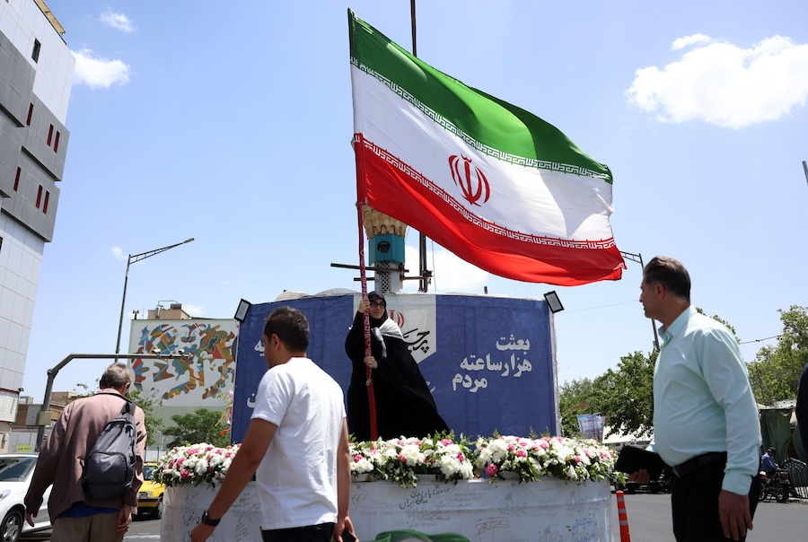 Una donna sventola la bandiera nazionale iraniana in una strada di Teheran, in Iran, il 17 maggio 2026. Il conflitto tra Iran e Stati Uniti continua, mentre il presidente americano Donald Trump ha ribadito le minacce di una nuova azione militare contro l'Iran. EPA/ABEDIN TAHERKENAREH (EPA)