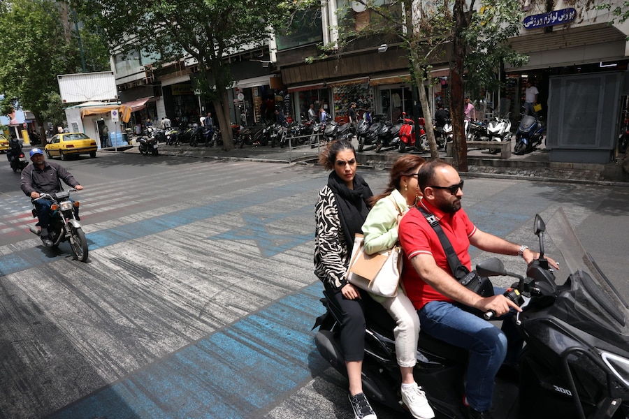 Alcuni iraniani passano in auto davanti a un dipinto raffigurante le bandiere degli Stati Uniti e di Israele in una strada di Teheran, in Iran, il 17 maggio 2026. Il conflitto tra l'Iran e gli Stati Uniti continua, mentre il presidente americano Donald Trump ha ribadito le minacce di una nuova azione militare contro l'Iran. EPA/ABEDIN TAHERKENAREH (EPA)