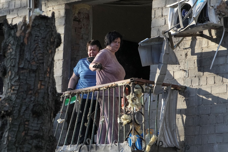 Alcuni residenti si affacciano dal balcone di un condominio danneggiato durante un attacco missilistico russo, nel contesto dell'offensiva russa contro l'Ucraina, a Dnipro. (REUTERS/Stringer)
