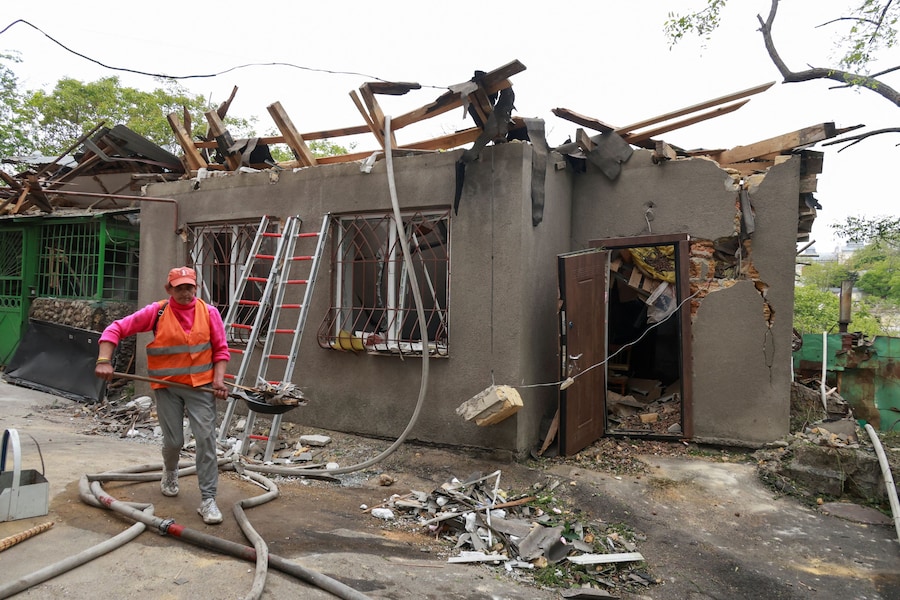 Un operaio comunale rimuove i detriti accanto a un edificio danneggiato durante gli attacchi notturni dei droni russi, nel contesto dell'offensiva russa contro l'Ucraina, a Odessa. (REUTERS/Nina Liashonok)