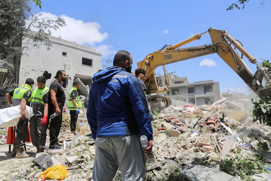 La gente si raduna sul luogo di un attacco israeliano, che secondo il Ministero della Salute libanese ha causato la morte di diverse persone, a Deir Qanoun al-Nahr, nel distretto di Tiro, nel sud del Libano. (REUTERS)