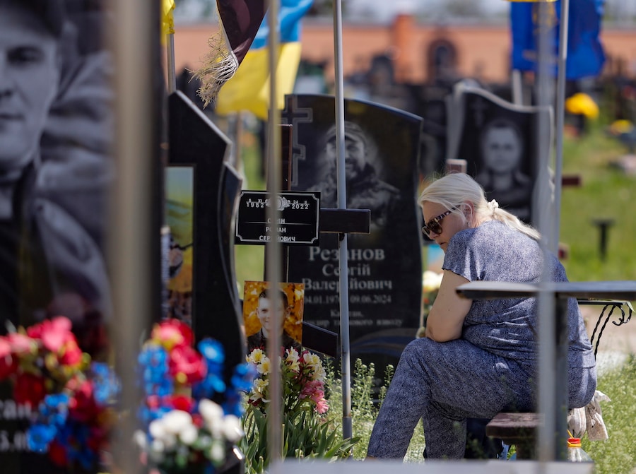 Un gruppo di persone in lutto si riunisce in segno di cordoglio presso le tombe degli agenti di polizia Igor Lisitsyn e Igor Radzyminsky, caduti in combattimento sul fronte, in un cimitero militare a Kharkiv, nell’Ucraina nord-orientale, il 20 maggio 2026, nel pieno dell’invasione russa. EPA/YEVHEN TITOV (EPA)