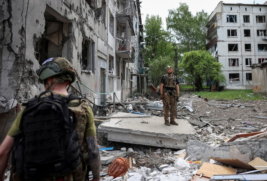 I militari della divisione missili antiaerei della 15ª Brigata "Kara-Dag" dell'Incarico Operativo della Guardia Nazionale ucraina si trovano nei pressi di edifici residenziali distrutti, nel contesto dell'attacco russo all'Ucraina, nella città di Bilozerske, in prima linea nella regione di Donetsk. (REUTERS/Anatolii Stepanov)