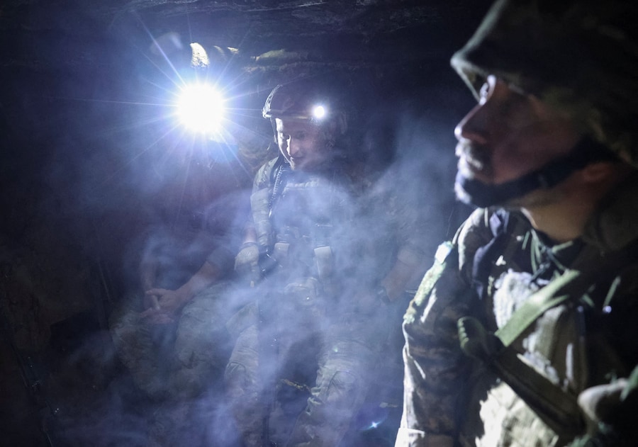 I militari della divisione missili antiaerei della 15ª Brigata "Kara-Dag" dell'Incarico Operativo della Guardia Nazionale ucraina si riparano in una trincea durante i bombardamenti, nel contesto dell'attacco russo all'Ucraina, nei pressi della città di Bilozerske, in prima linea nella regione di Donetsk. (REUTERS/Anatolii Stepanov)