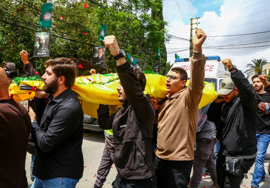 I partecipanti al funerale trasportano una salma durante la cerimonia funebre delle vittime dell'attacco israeliano di martedì, a Deir Qanoun al-Nahr, nel sud del Libano. (REUTERS)