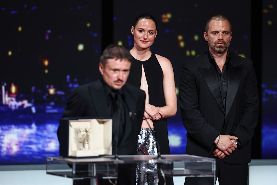 Il regista Cristian Mungiu, vincitore della Palma d'Oro per il film "Fjord", parla accanto ai membri del cast Renate Reinsve e Sebastian Stan, sul palco durante la cerimonia di chiusura del 79° Festival di Cannes a Cannes, in Francia, il 23 maggio 2026. REUTERS/Sarah Meyssonnier (REUTERS)