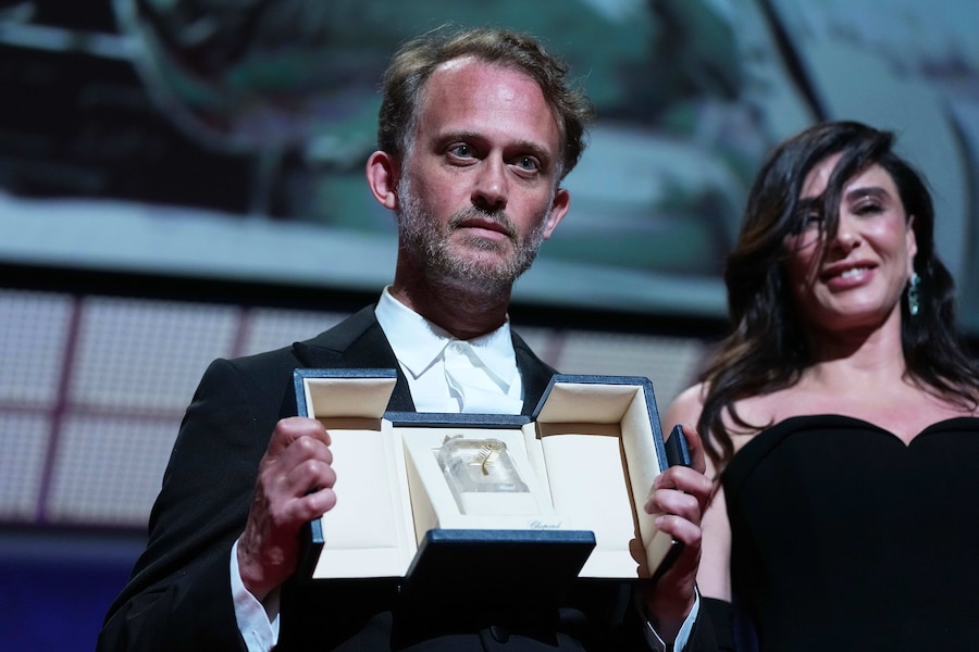 Emmanuel Marre, a sinistra, ritira il premio per la migliore sceneggiatura del film "Un uomo del suo tempo" durante la cerimonia di premiazione della 79ª edizione del Festival internazionale del cinema di Cannes, nel sud della Francia, sabato 23 maggio 2026. (AP Photo/Andreea Alexandru) (APN)