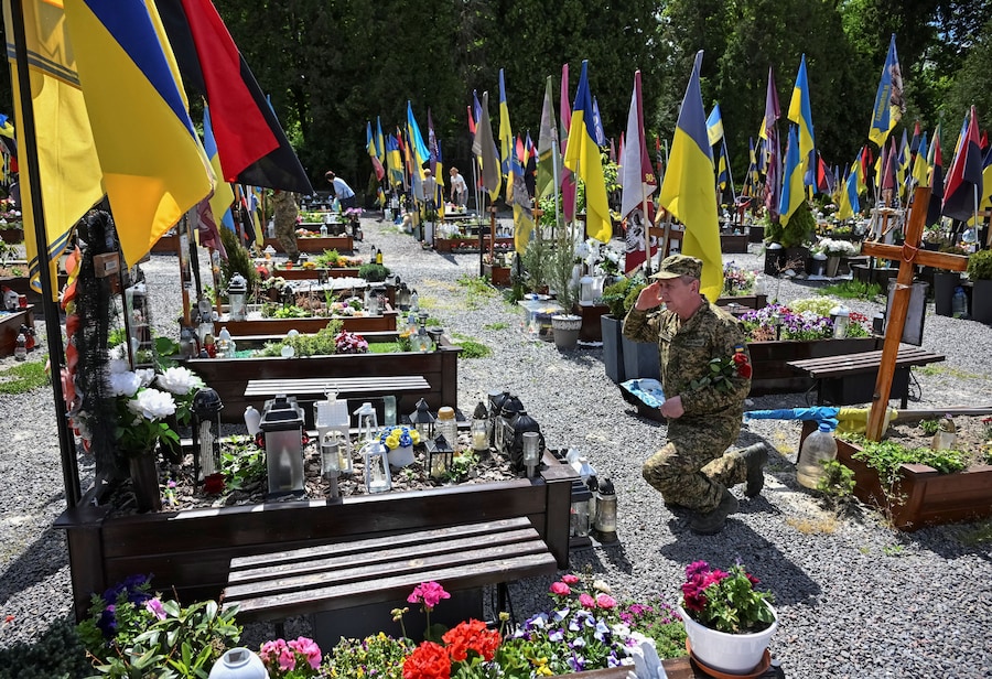 Un militare ucraino si reca sulla tomba di un commilitone caduto, mentre gli ucraini celebrano la Giornata degli Eroi, nel contesto dell'attacco russo all'Ucraina, al cimitero di Lychakiv a Leopoli, in Ucraina, il 23 maggio 2026. REUTERS/Stringer (REUTERS)