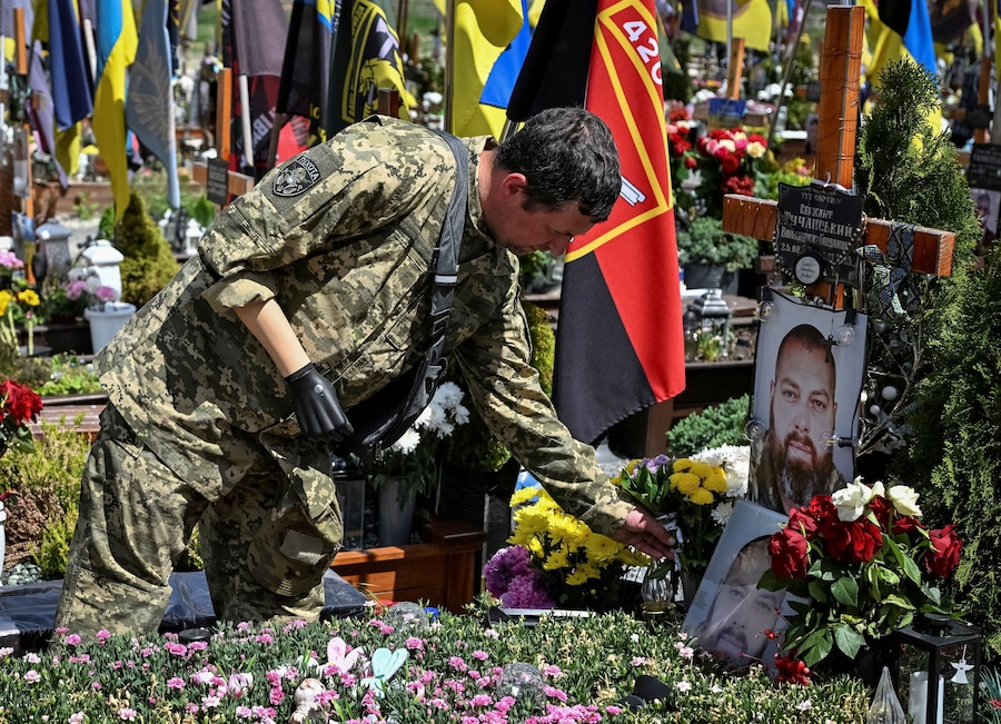 Un militare ucraino si reca sulla tomba di un commilitone caduto, mentre gli ucraini celebrano la Giornata degli Eroi, nel contesto dell'attacco russo all'Ucraina, al cimitero di Lychakiv a Leopoli, Ucraina, il 23 maggio 2026. REUTERS/Stringer IMMAGINI DEL GIORNO DI TPX (REUTERS)