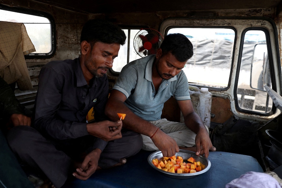 Il camionista Mahendrakumar mangia un mango all'interno del suo camion mentre è in coda per fare rifornimento in una stazione di servizio, mentre l'India deve affrontare l'aumento dei prezzi del petrolio a seguito della chiusura dello Stretto di Hormuz nel contesto del conflitto tra Stati Uniti, Israele e Iran, a Kandla, nel Gujarat (India), il 23 maggio 2026. REUTERS/Amit Dave (REUTERS)