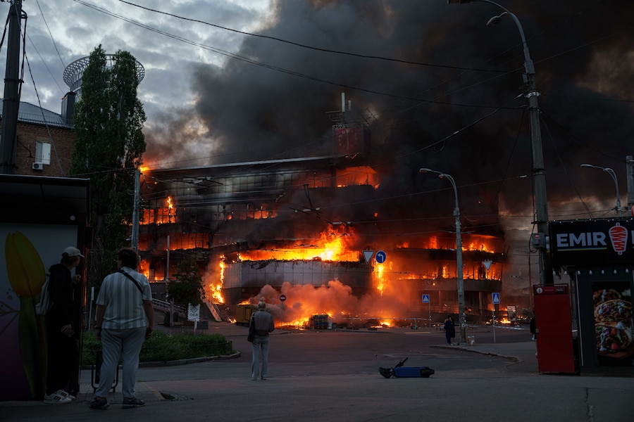 La gente osserva un centro commerciale in fiamme dopo un attacco russo a Kiev, in Ucraina, domenica 24 maggio 2026. (Foto AP/Evgeniy Maloletka) (APN)