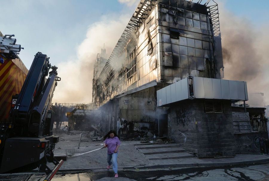 Un residente locale cammina mentre il fumo si alza dal luogo in cui un attacco russo ha colpito un centro commerciale a Kiev, in Ucraina, il 24 maggio 2026, nel corso dell'invasione russa. Più di 600 droni e 90 missili hanno colpito diversi siti in tutta Kiev nella notte del 24 maggio, causando almeno due vittime confermate e più di 80 feriti, secondo il presidente ucraino Volodymyr Zelensky. EPA/SERGEY DOLZHENKO (EPA)