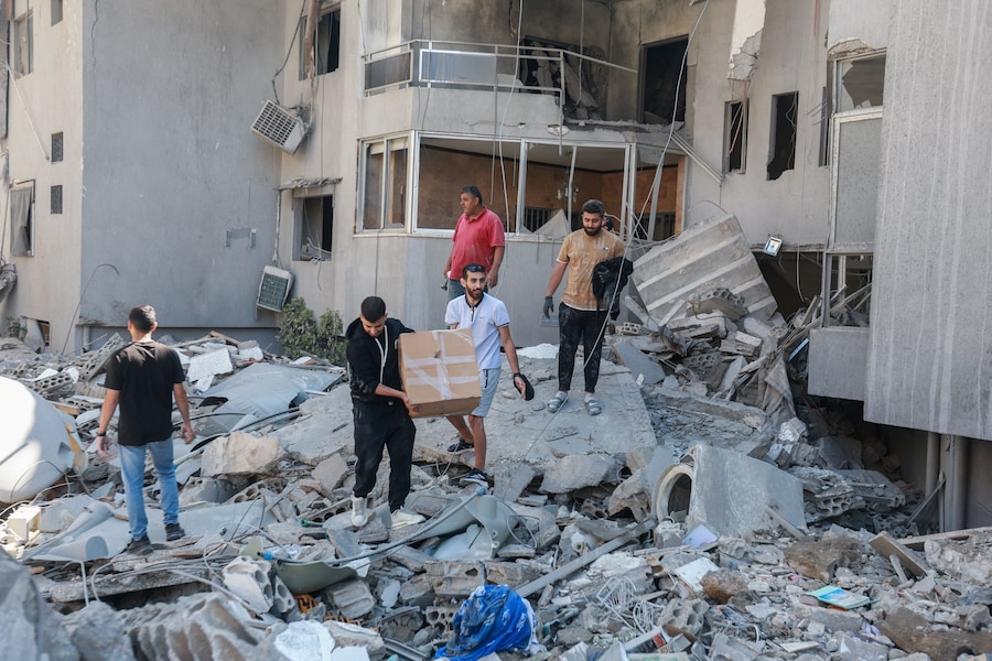 La gente ispeziona i danni sul luogo di un attacco israeliano sferrato nella città meridionale di Tiro, in Libano. (REUTERS/Aziz Taher)