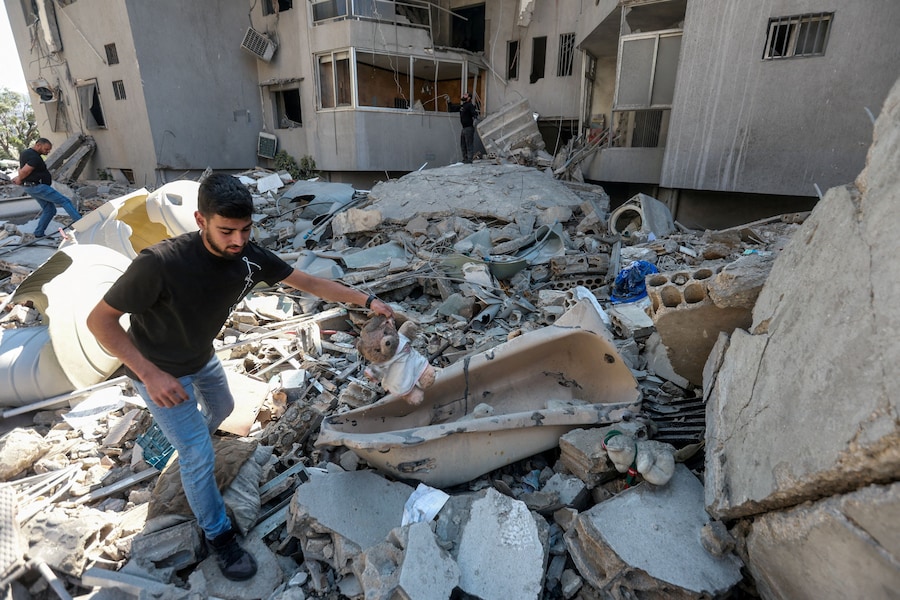 Un uomo tiene in mano un peluche sul luogo di un attacco israeliano sferrato nella città meridionale di Tiro, in Libano. (REUTERS/Aziz Taher)